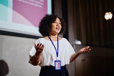 woman with lanyard giving a presentation
